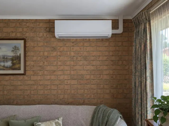 Split system indoor unit on a brick living room wall above a sofa in Reynella